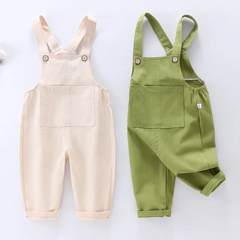 Cream and green children's bib overalls with buttoned straps and front pockets