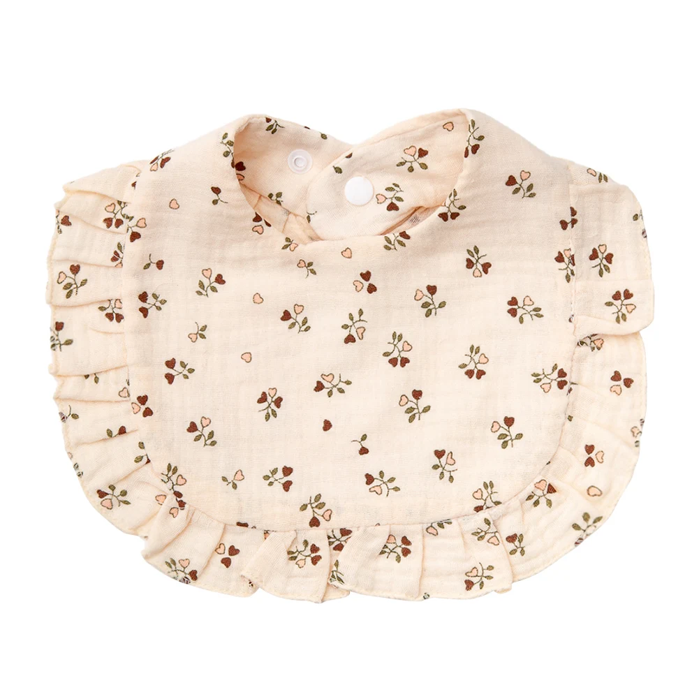 Cream cotton baby bib with tiny hearts, floral sprigs, and ruffled trim