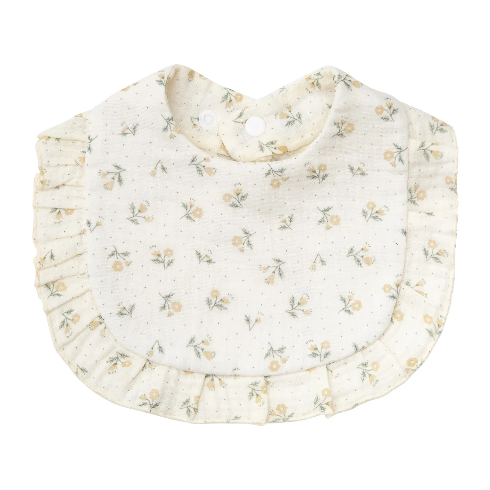 Light cream cotton baby bib with pale yellow flowers and a ruffled border