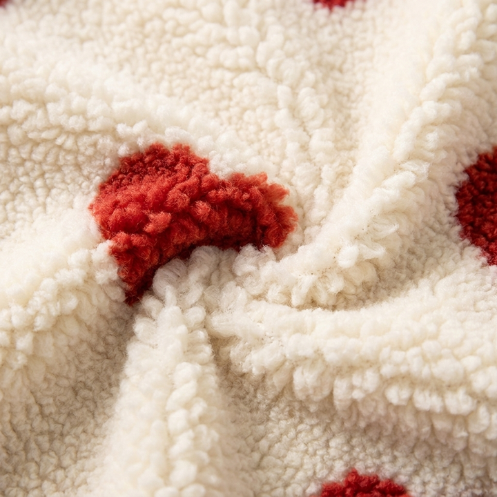 Close-up of cream Berber fleece with a raised red heart pattern