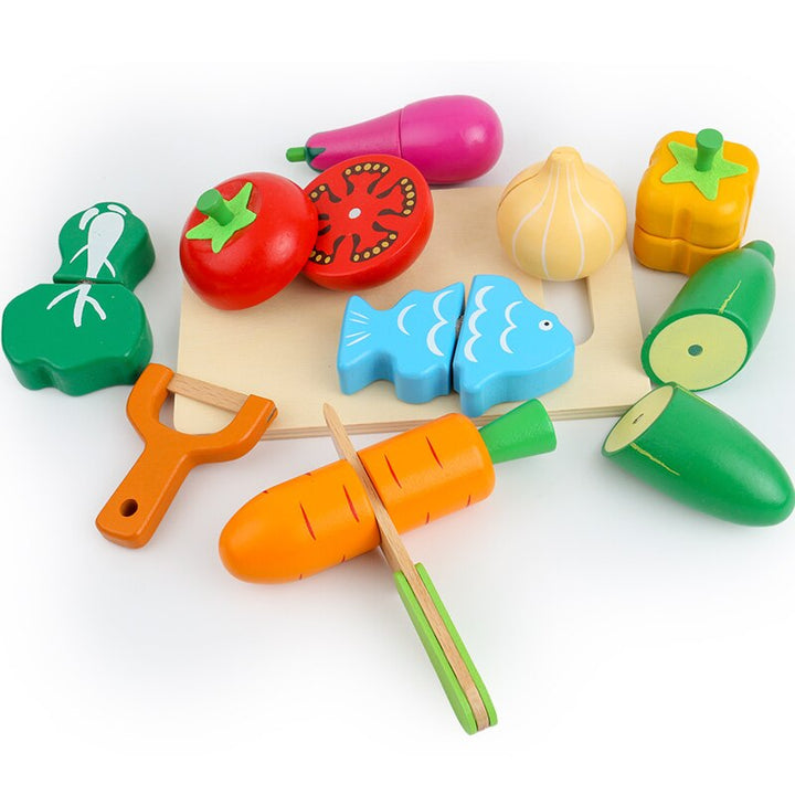 Cut-apart wooden vegetables and fish on a cutting board with a knife and orange peeler
