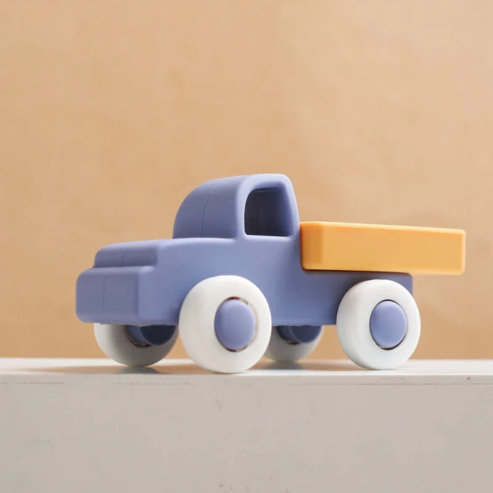 Dark blue silicone toy truck with a yellow bed and white wheels