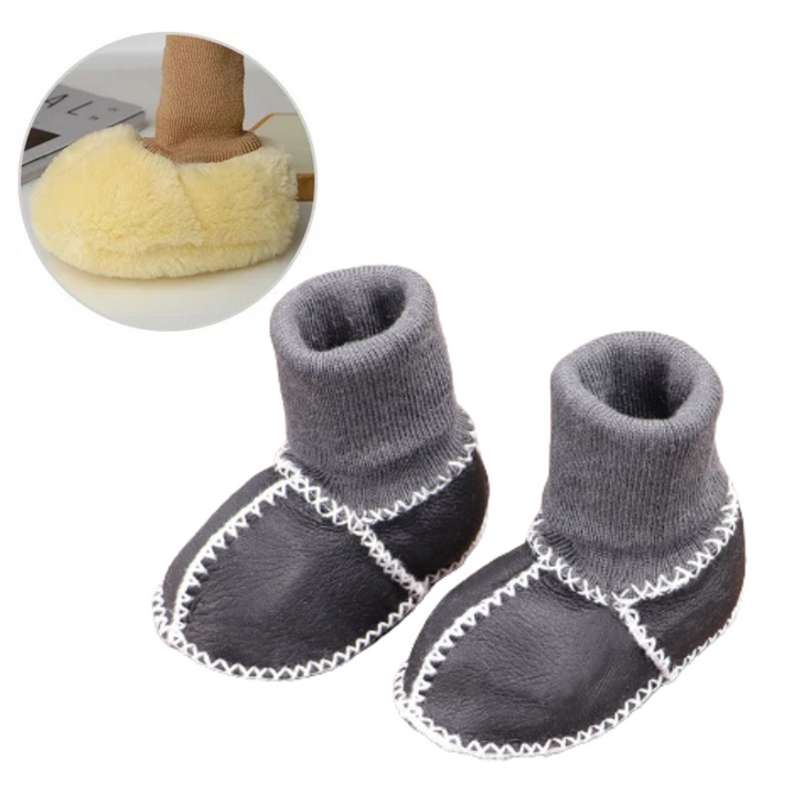 Dark gray baby slippers with rolled gray knit cuffs and white stitching