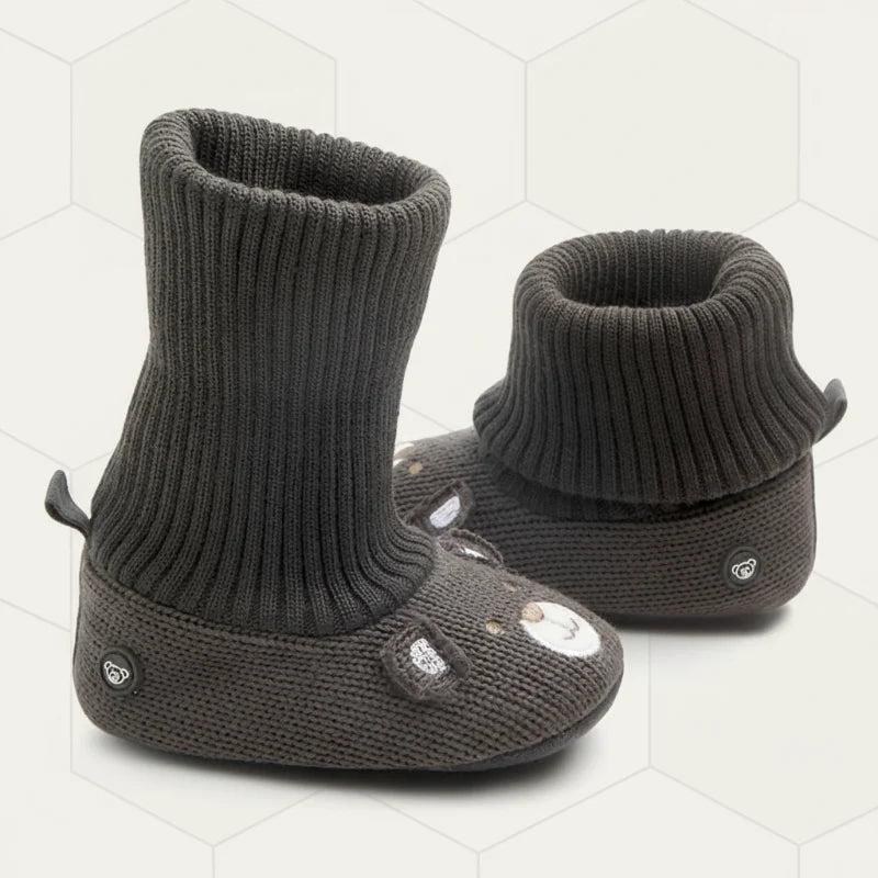 Dark gray knit baby booties showing one cuff extended and one folded over.