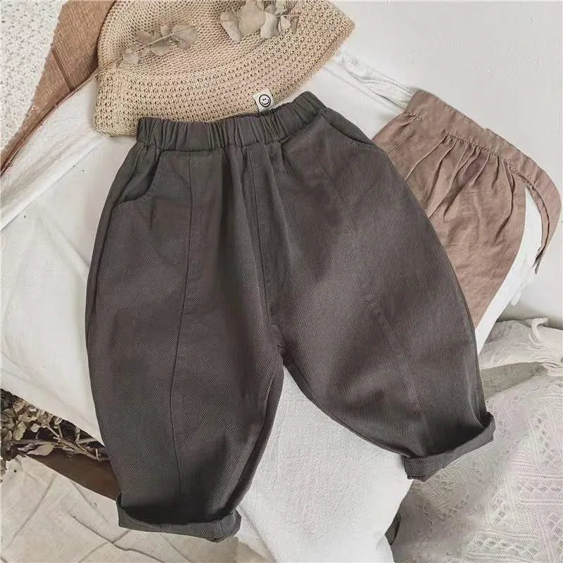Dark gray kids' pants with an elastic waist, side pockets, and rolled hems
