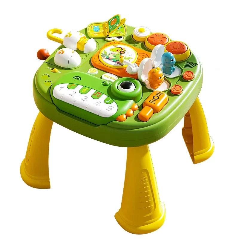 Green musical activity table with a frog-shaped piano, colorful play controls, and yellow legs