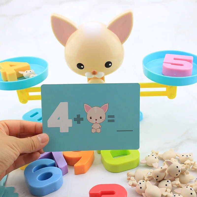 Dog balance scale with a math activity card, numeral weights, and small dog counters