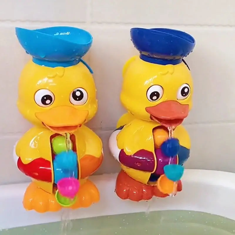 Two duck bath toys with water flowing from their beaks onto the front wheels