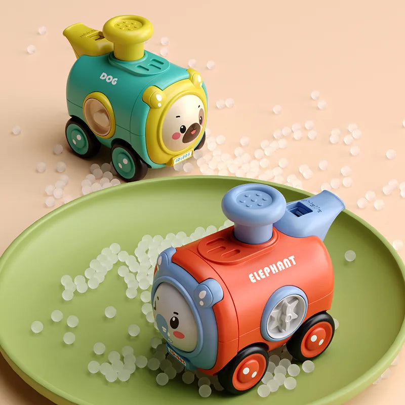 Red elephant and teal dog toy trains displayed on and beside a green tray.