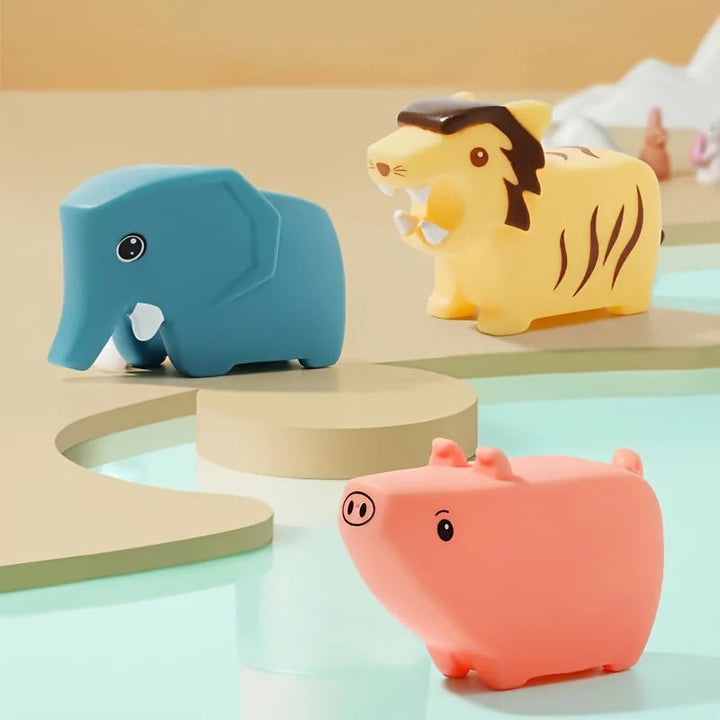 Blue elephant, yellow striped cat, and pink pig bath toys on display