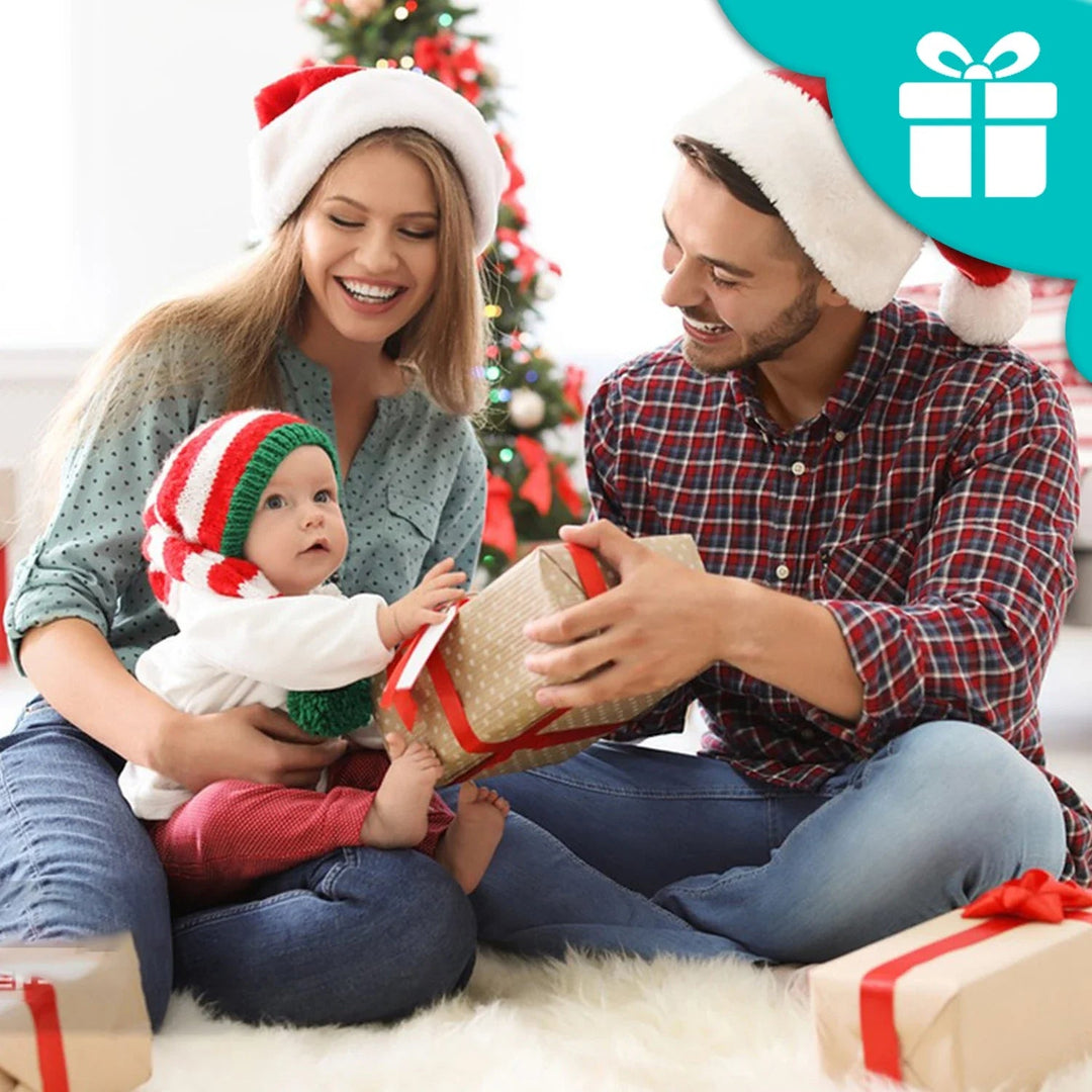 Parents sitting with a baby and wrapped gifts in a Christmas setting