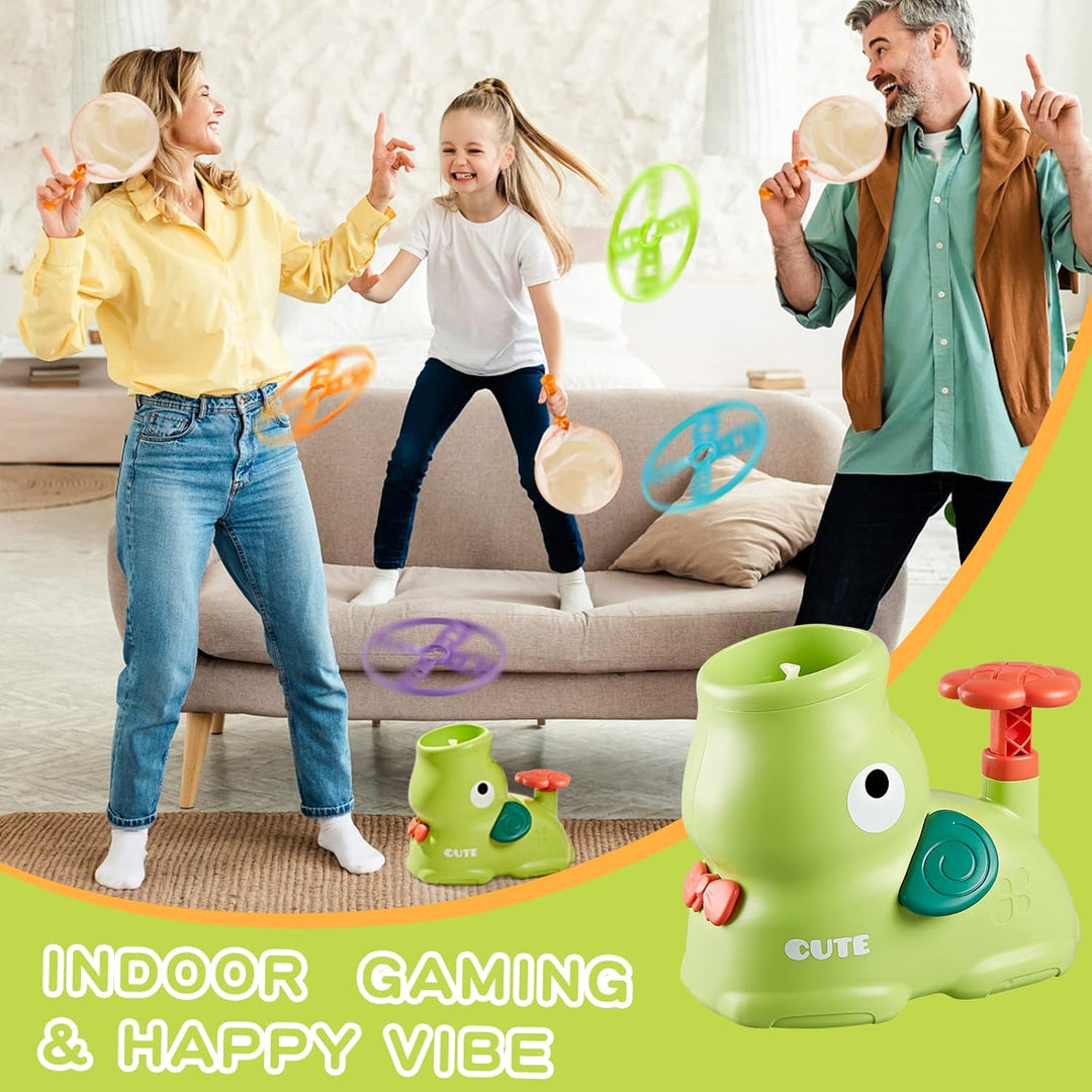 Family playing a flying-disc catching game indoors with nets and a green launcher