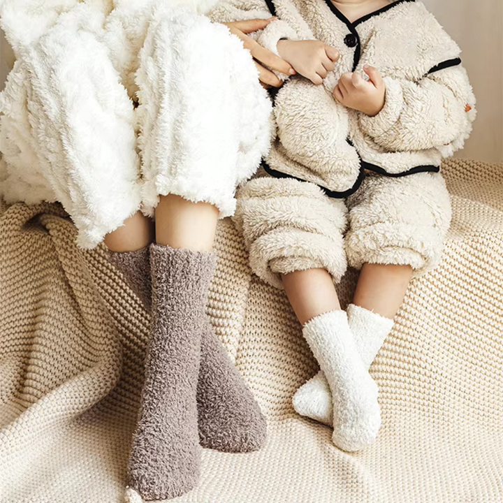 Fleece socks worn with cozy loungewear while sitting on a couch