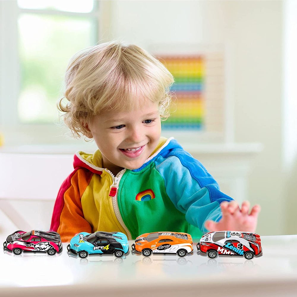 Child playing with four colorful stunt cars lined up on a table
