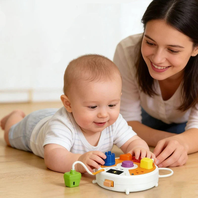 Child exploring the activity board on the floor with a parent nearby