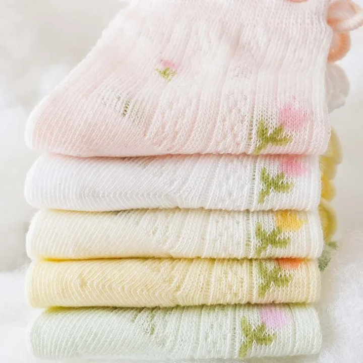 Stack of folded pastel socks showing the knit texture and small floral details.