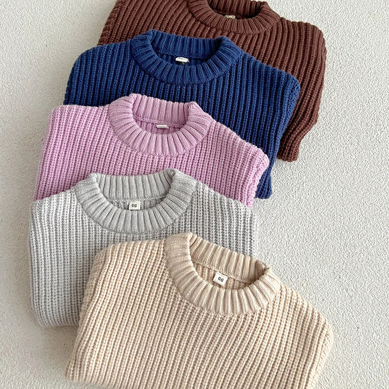 Folded cotton knit sweaters in apricot, gray, purple, dark blue, and brown.