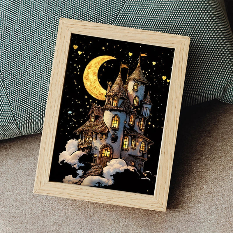 Moon-and-castle scratch artwork displayed in a wooden frame