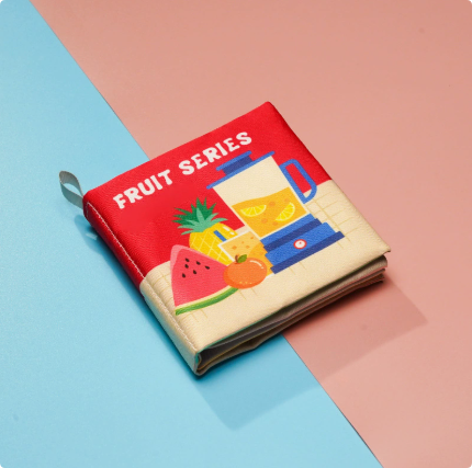 Fruit-themed cloth book with watermelon, pineapple, citrus and a blender on the cover