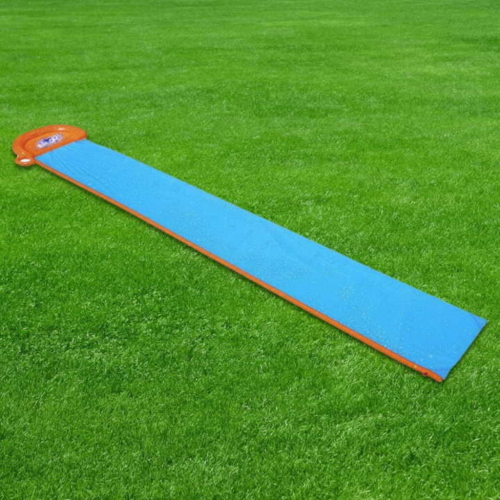 Full-length blue single-lane water slide with orange edging laid out on grass