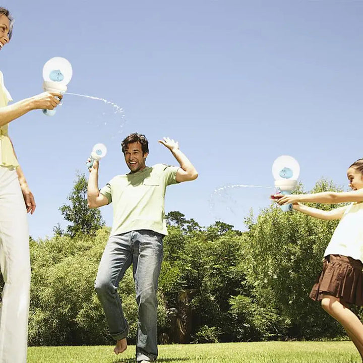 People playing with globe-top water guns on a sunny lawn