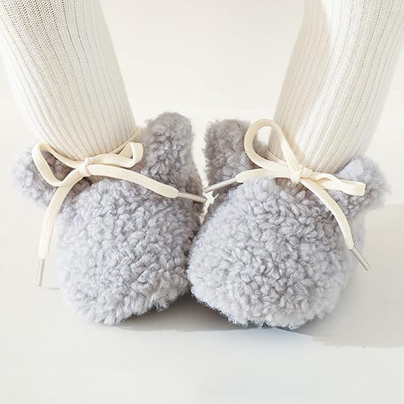 Gray bunny slippers with cream bows worn over white ribbed socks