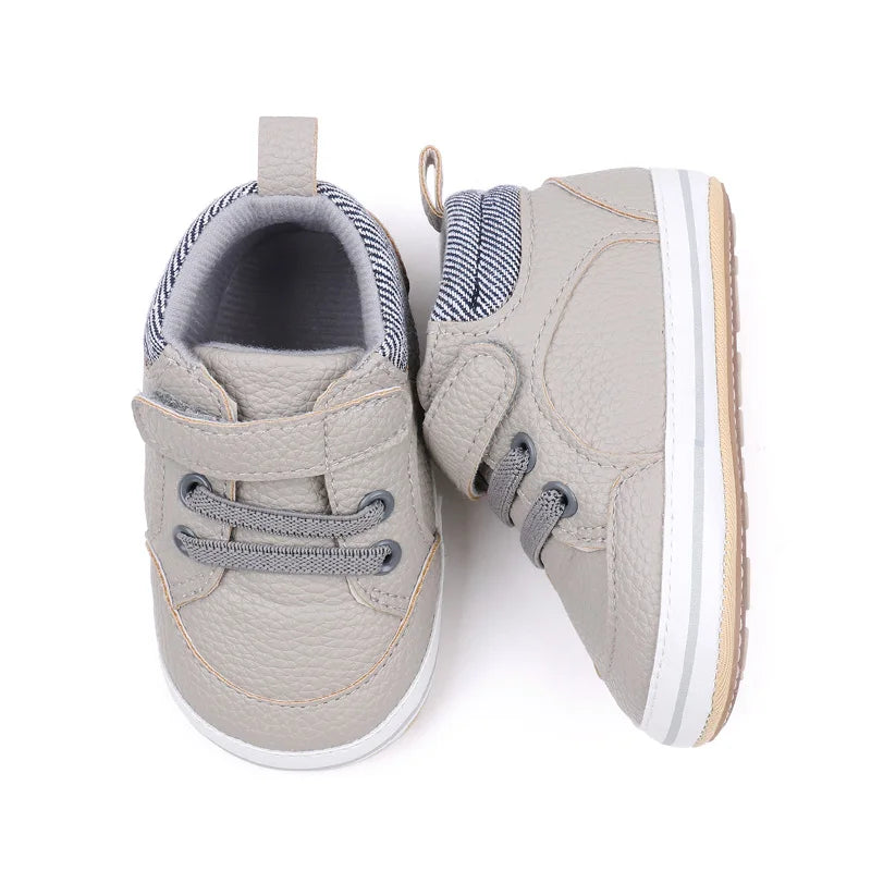 Gray baby sneakers shown from above and the side, with white sole trim and striped collars