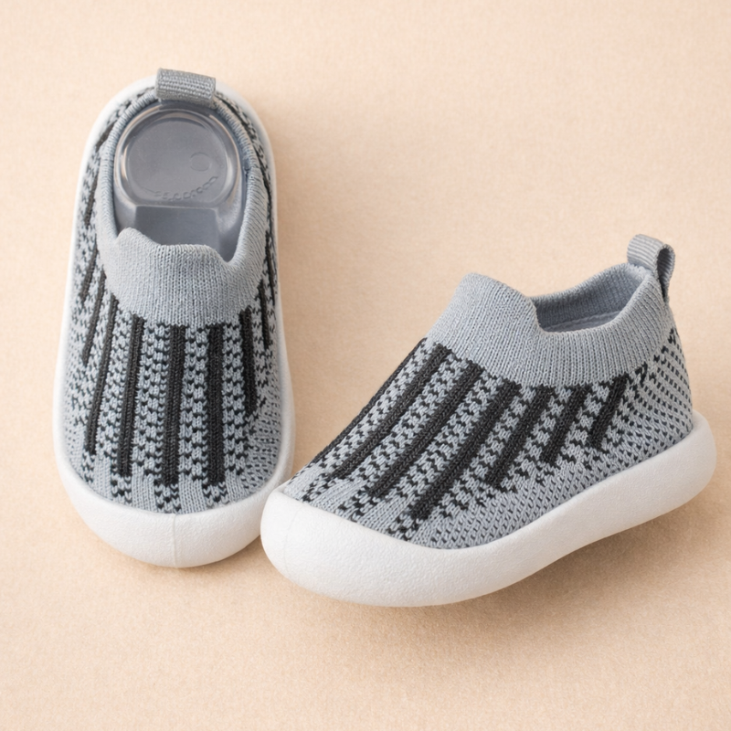 Gray mesh sneakers with black vertical stripes and white soles.