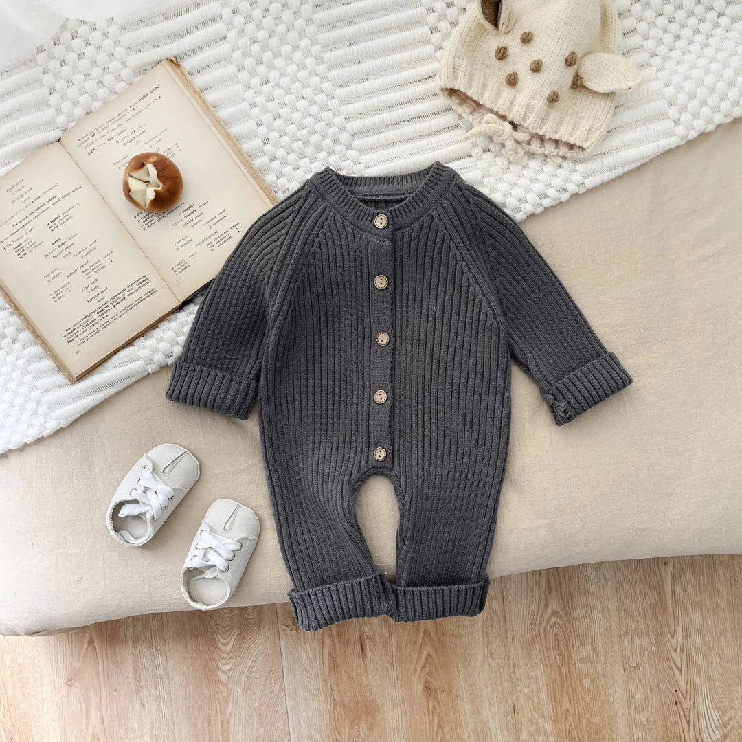 Gray long-sleeve baby romper laid flat with front buttons and rolled cuffs