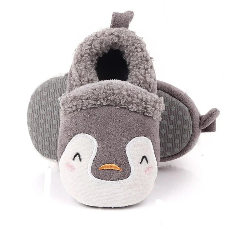 Gray penguin baby slippers with white faces and dotted soles.