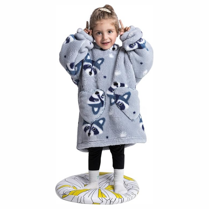 Child wearing a gray raccoon-print hooded blanket with two front pockets