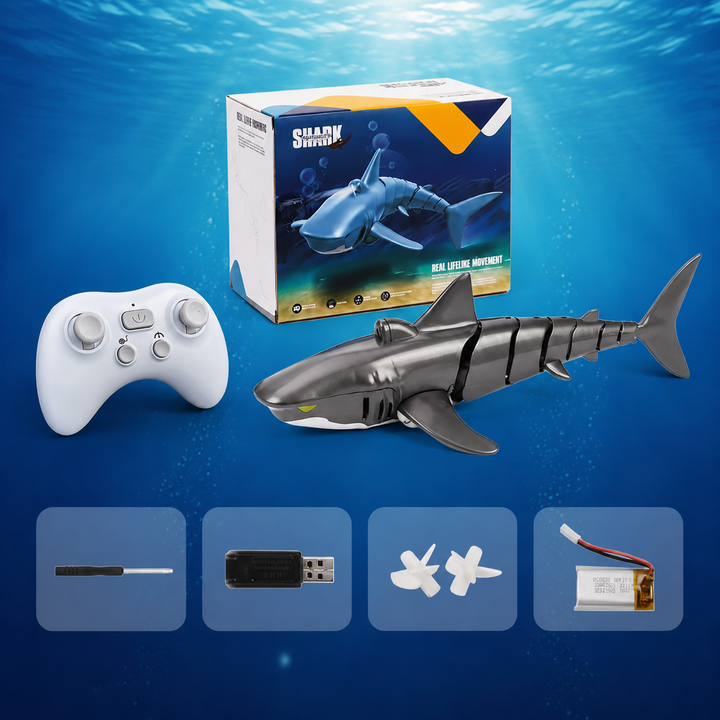 Gray RC shark with a white controller, retail box and charging accessories