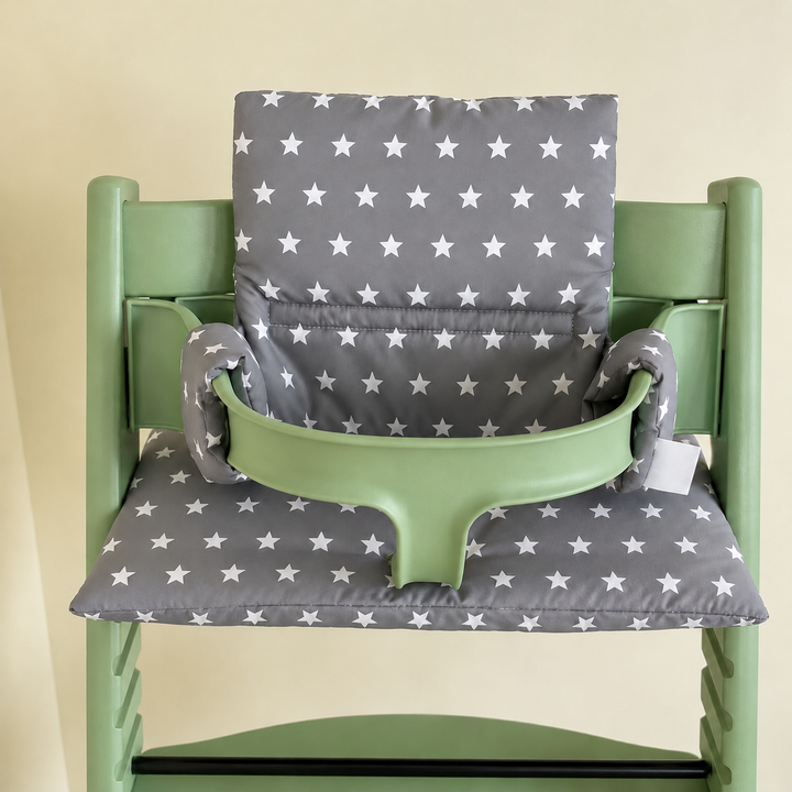Gray cushion with white stars fitted to a mint-green high chair