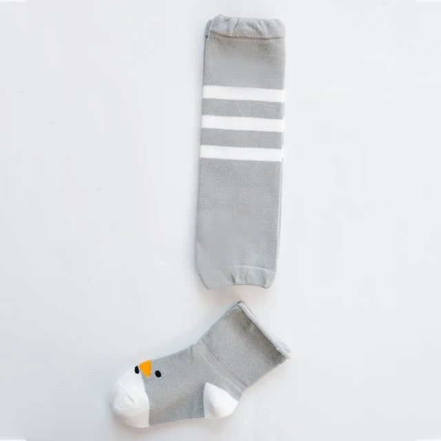 Gray leg warmer with three white stripes and a coordinating gray animal-face baby sock.