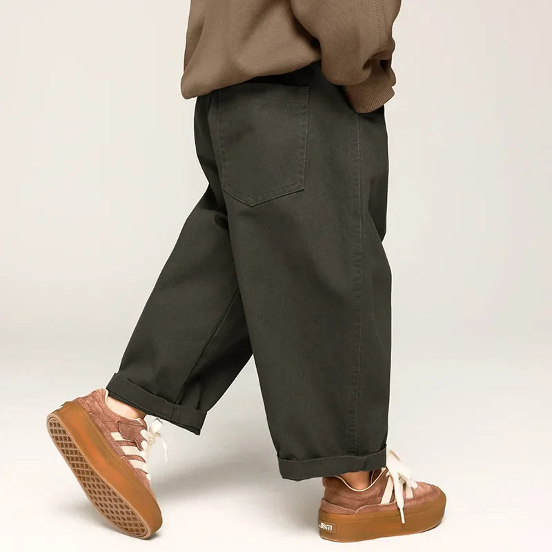 Rear side view of gray wide-leg pants showing a back patch pocket and rolled cuffs.