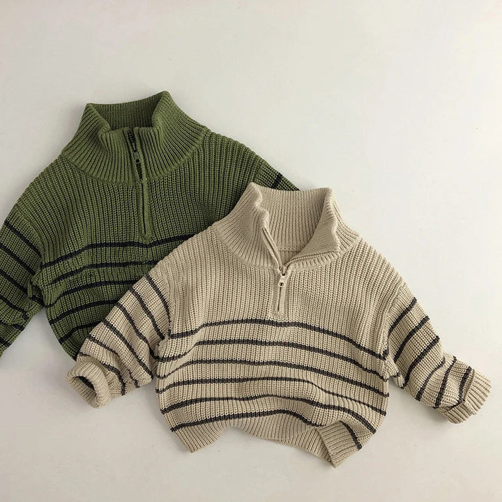 Green and beige striped cotton zip-neck sweaters laid flat together