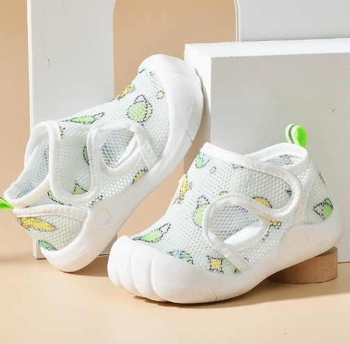 White mesh sandals with green citrus prints, pale trim and green heel loops