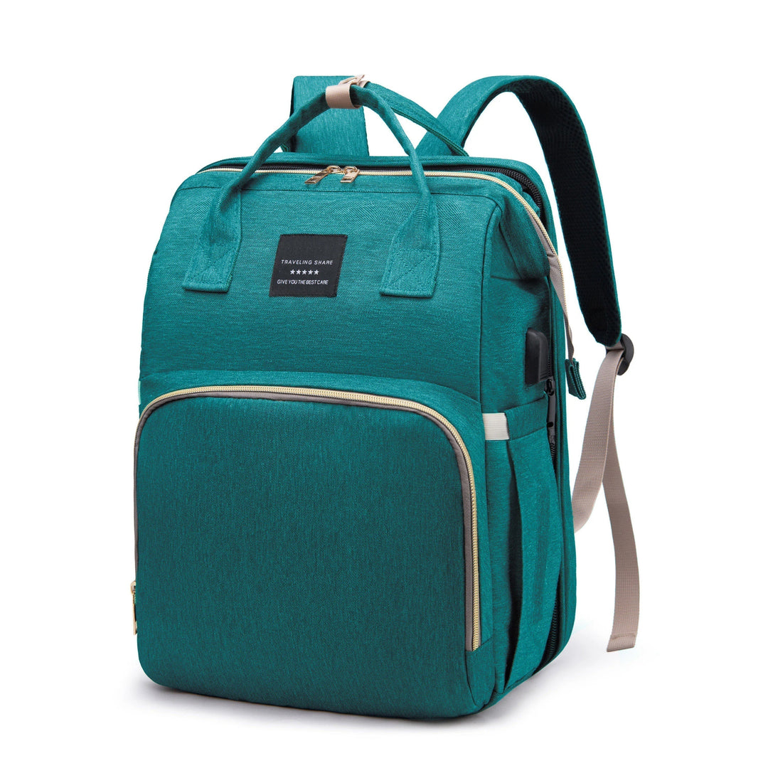 Green diaper backpack with top handles and front and side pockets.