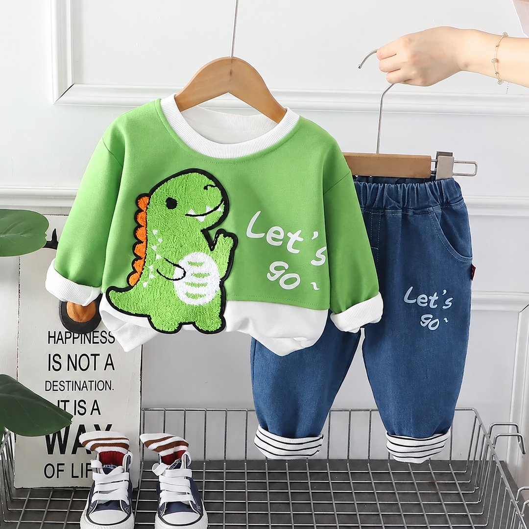 Green dinosaur sweatshirt with white cuffs and blue pants with an elastic waist