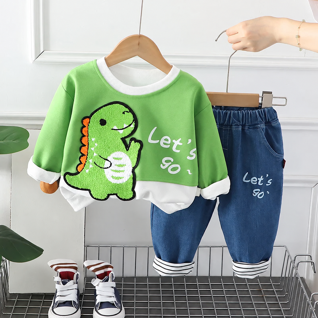 Green dinosaur sweatshirt and blue pants with an elastic waistband and striped cuffs