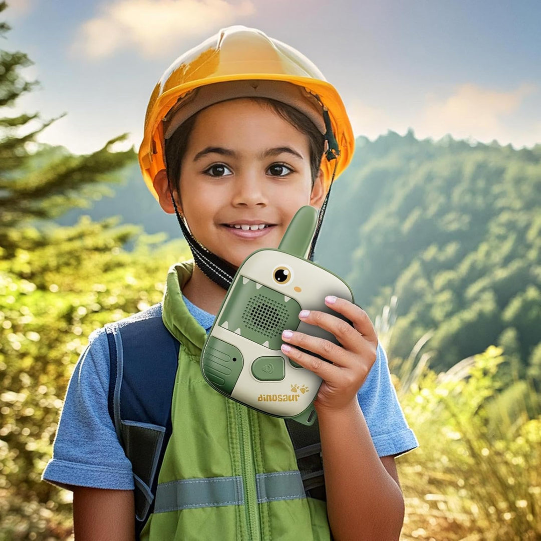 Child holding a green dinosaur walkie-talkie outdoors while wearing a hard hat and vest