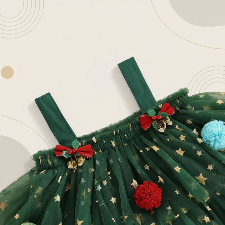 Close-up of green dress shoulder straps, small red bows, and gold star accents