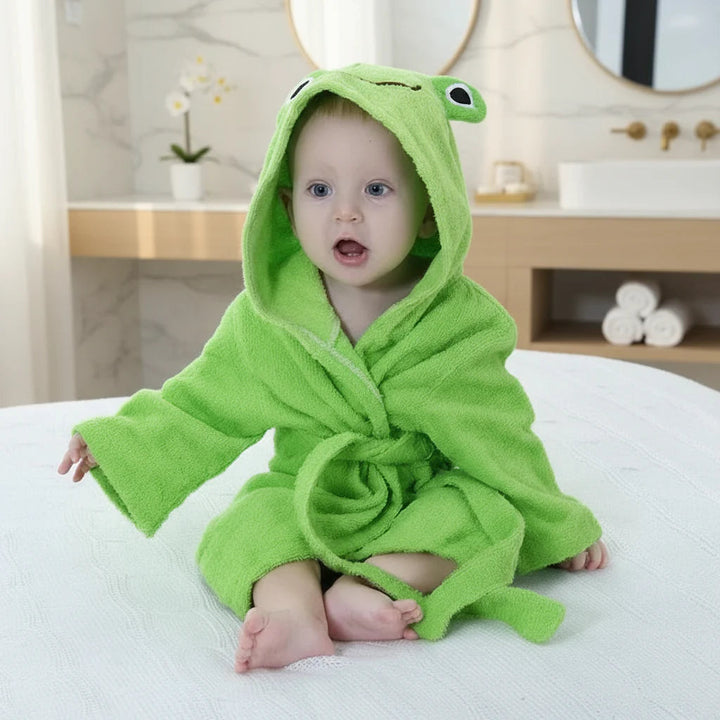 Baby wearing a green frog bathrobe with raised eyes on the hood and a tie belt