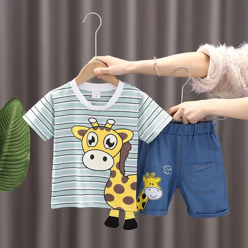 Green striped giraffe T-shirt held beside blue shorts with an elastic waistband