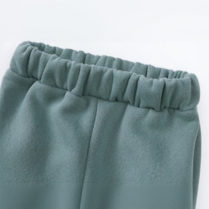 Close-up of the gathered elastic waistband on green jogger pants