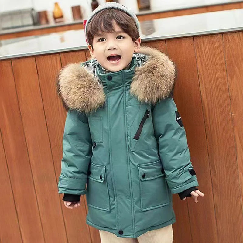 Child wearing a green hooded winter coat with a front zipper and flap pockets