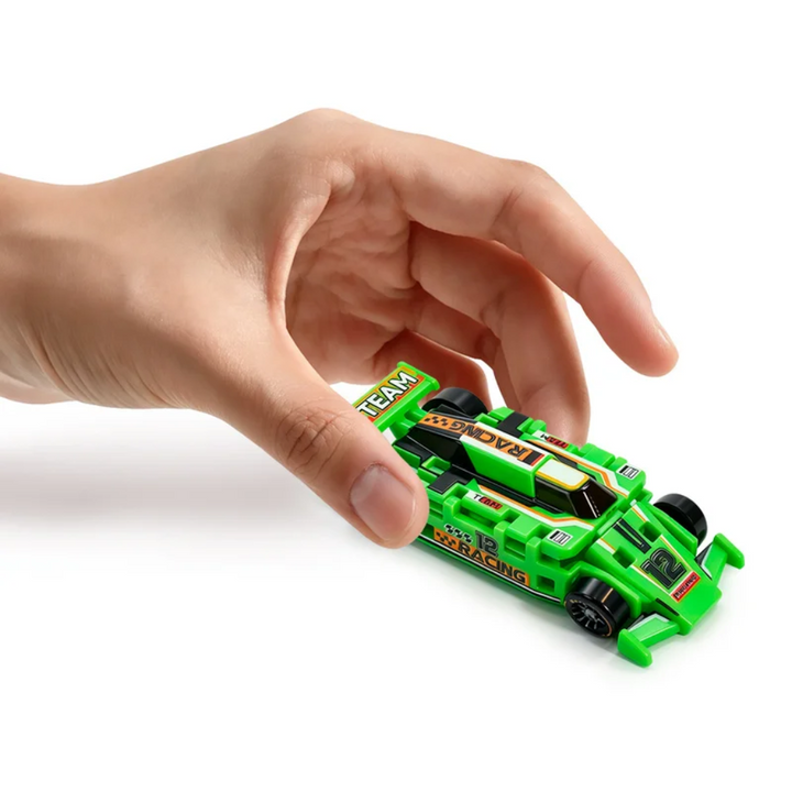 Hand holding a green transforming race car in its raised form.