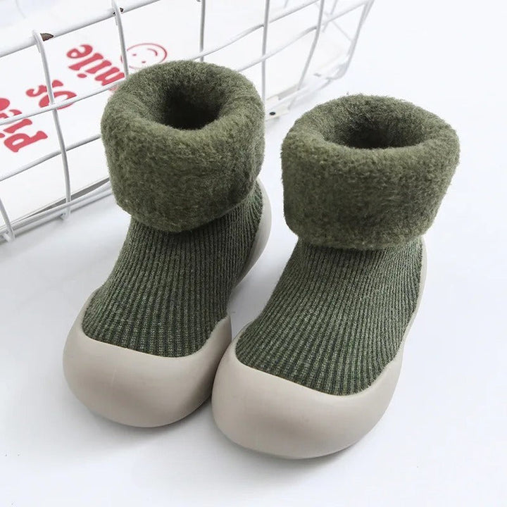 Green ribbed baby socks with plush folded cuffs and light-colored soles