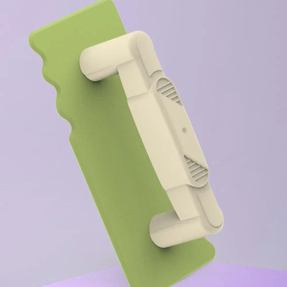 Close-up of a green sand spatula with a cream handle and textured grip