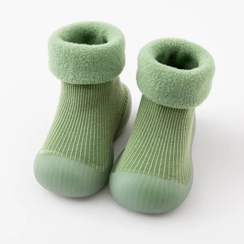 Green sock shoes with ribbed uppers, soft folded cuffs, and matching rubber soles.